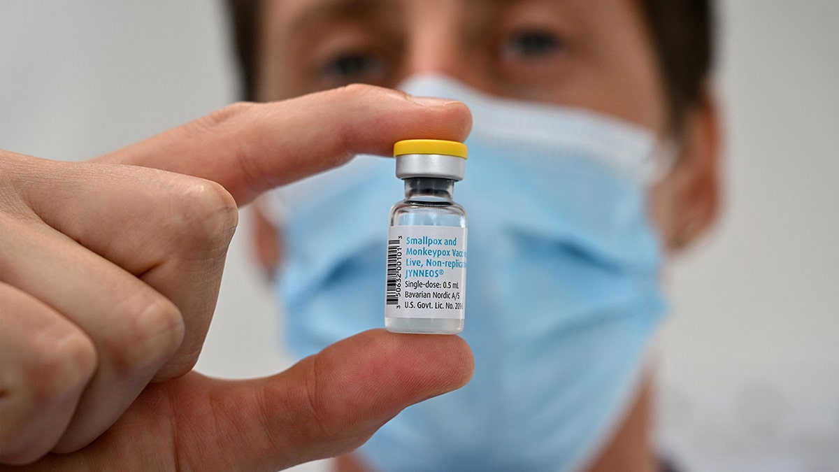 masked man holding vial