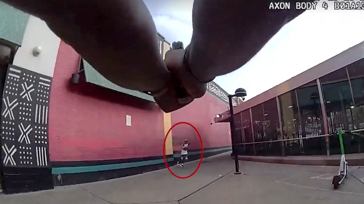 An officer pointing his gun at the suspect