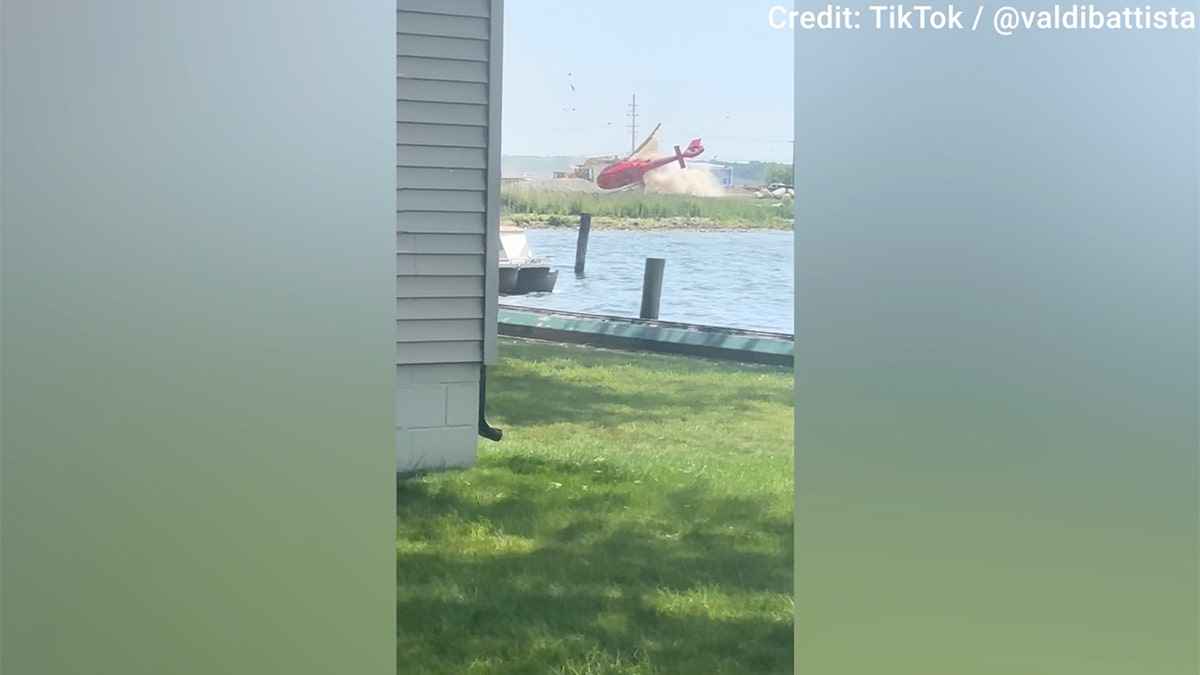 A red helicopter was seen hovering over land before crashing near a Michigan restaurant on Sunday.